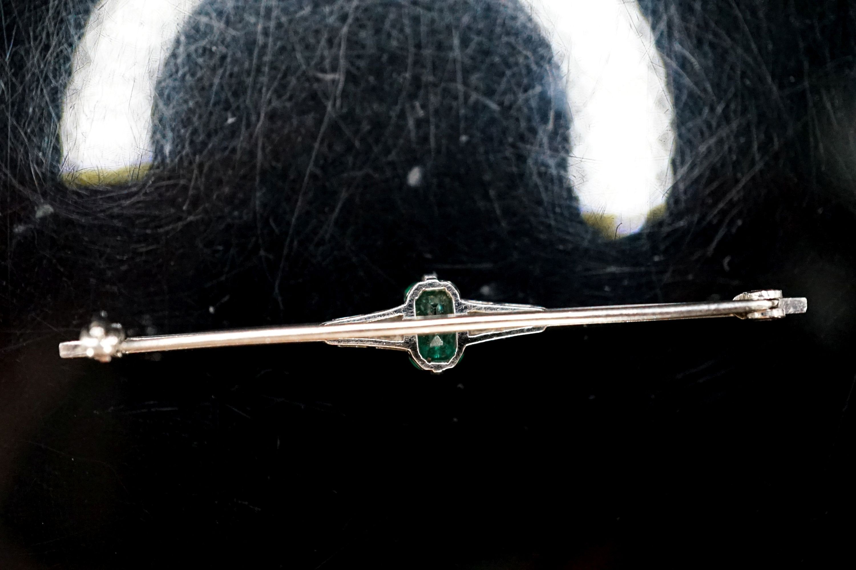 A boxed 1920's white metal (stamped pt), emerald and diamond chip set bar brooch, 51mm, gross weight 3.1 grams.